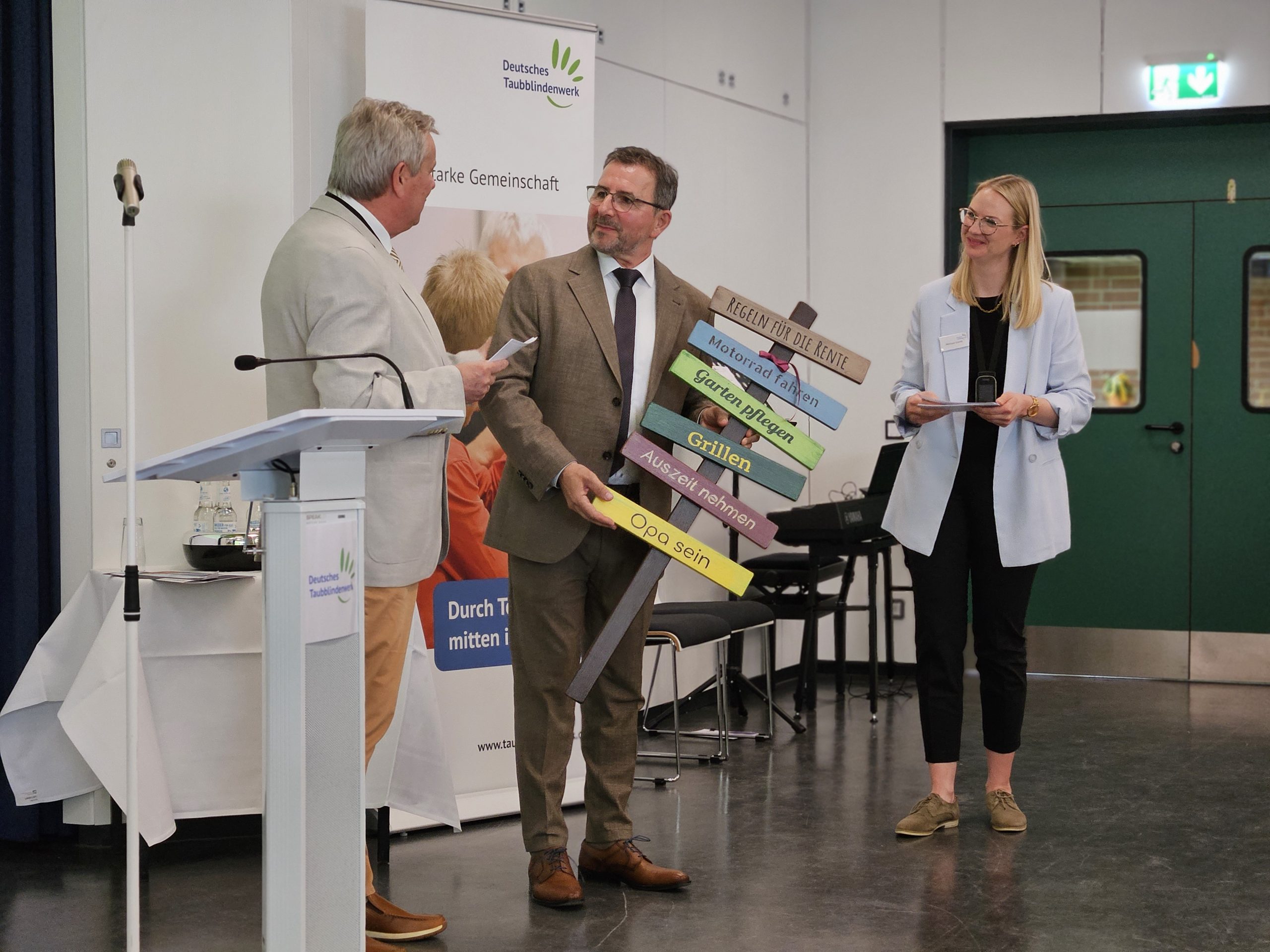 Jürgen Hennies und Melissa Glomb überreichen Volker Biewald sein Abschiedsgeschenk