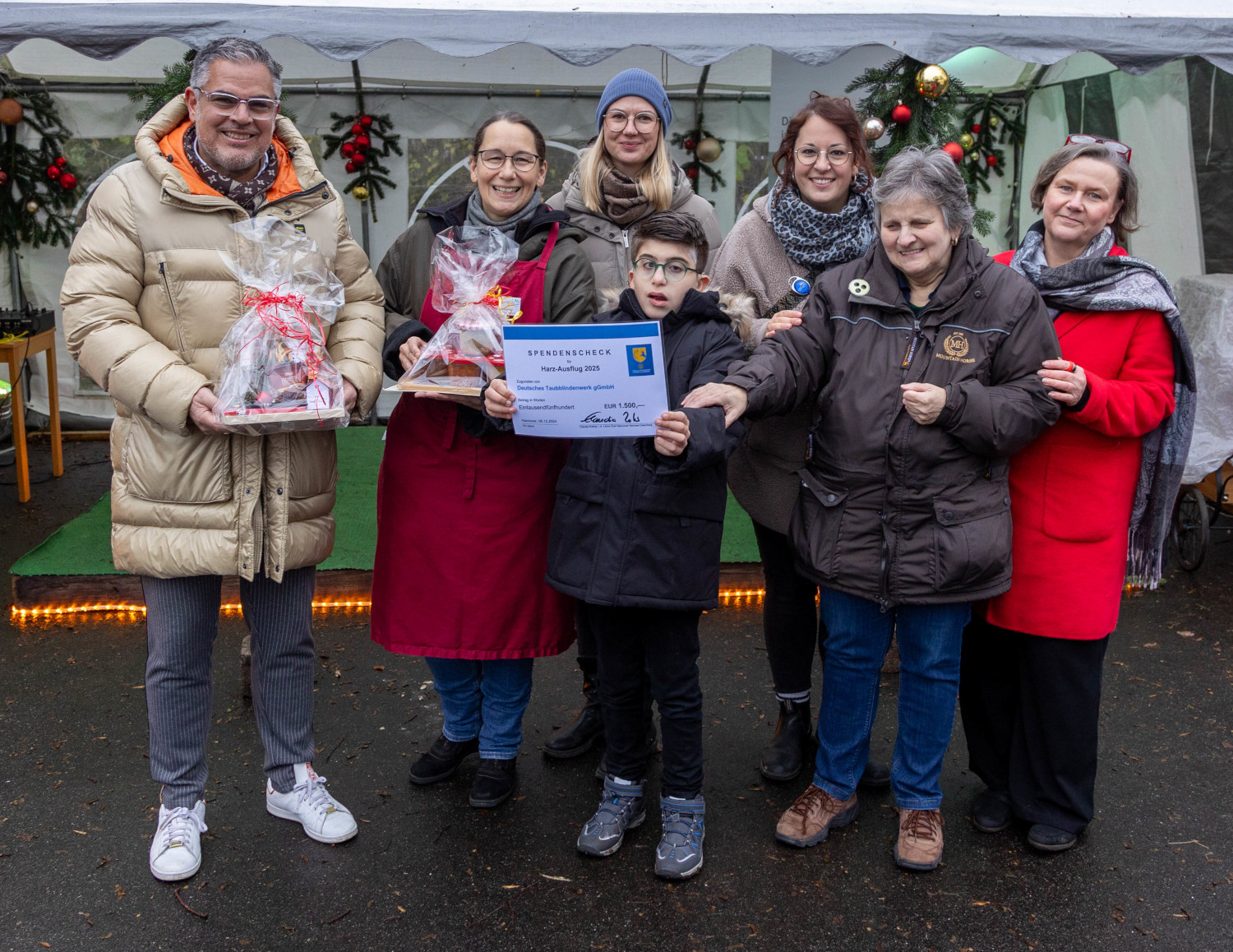 Verschiedene Menschen stehen auf dem Weihnachtsmarkt nebeneinander