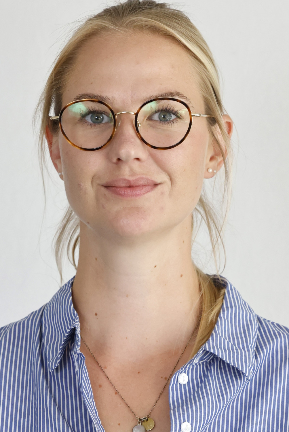 Eine Frau mit Brille schaut in Richtung des Fotografen